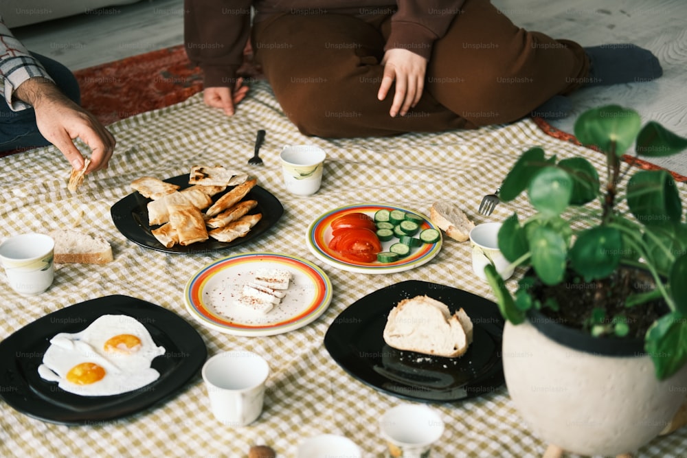 uma mesa coberta com pratos de comida ao lado de um vaso de planta