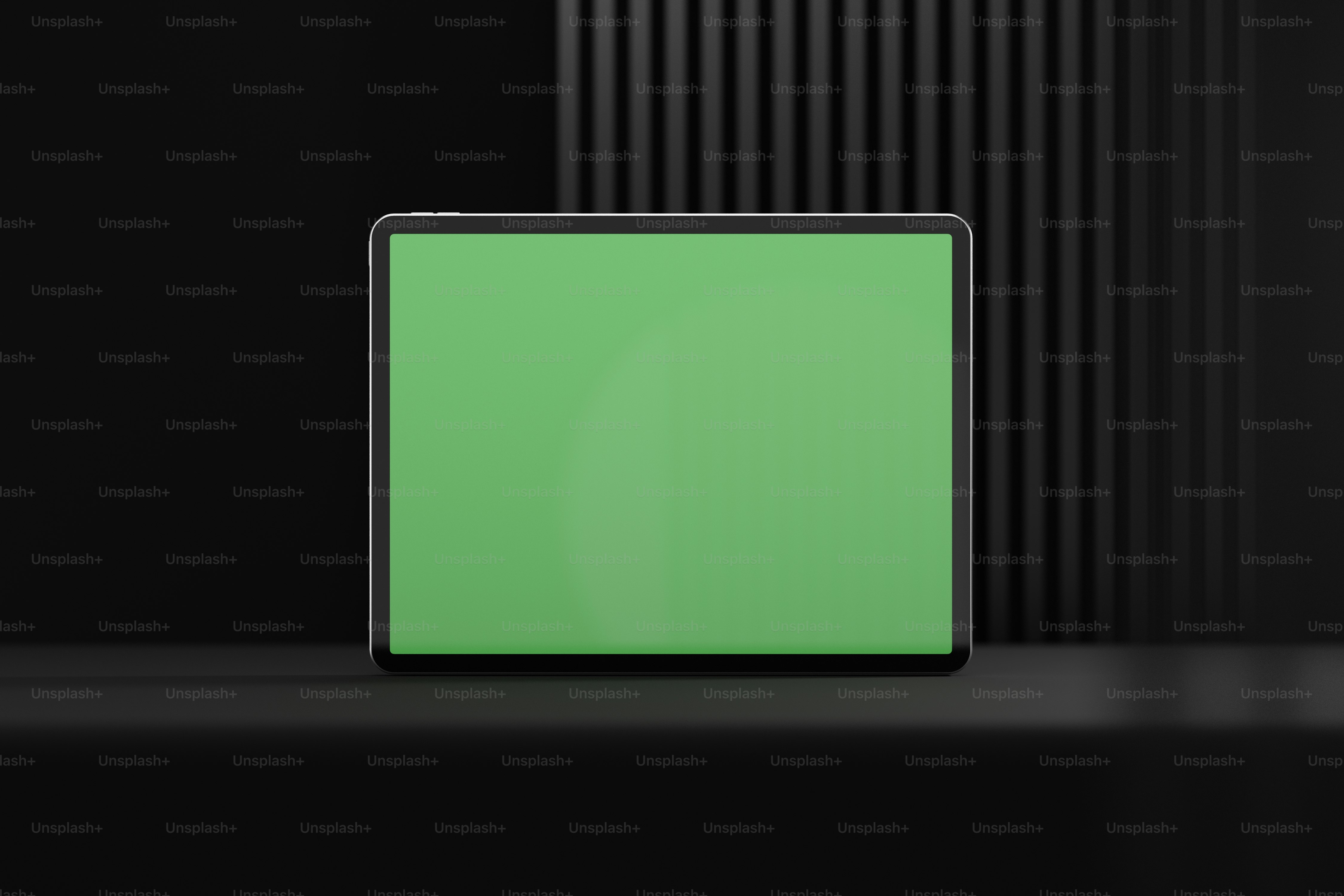 a tablet with a green screen on a black background