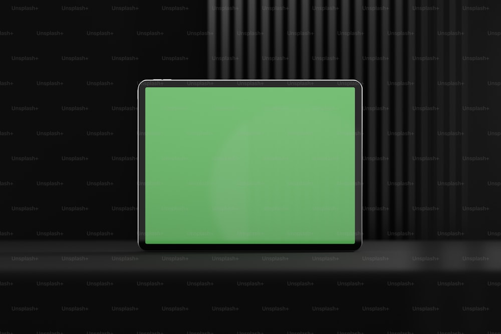 a tablet with a green screen on a black background