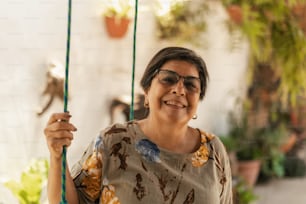 a woman smiles while holding onto a swing