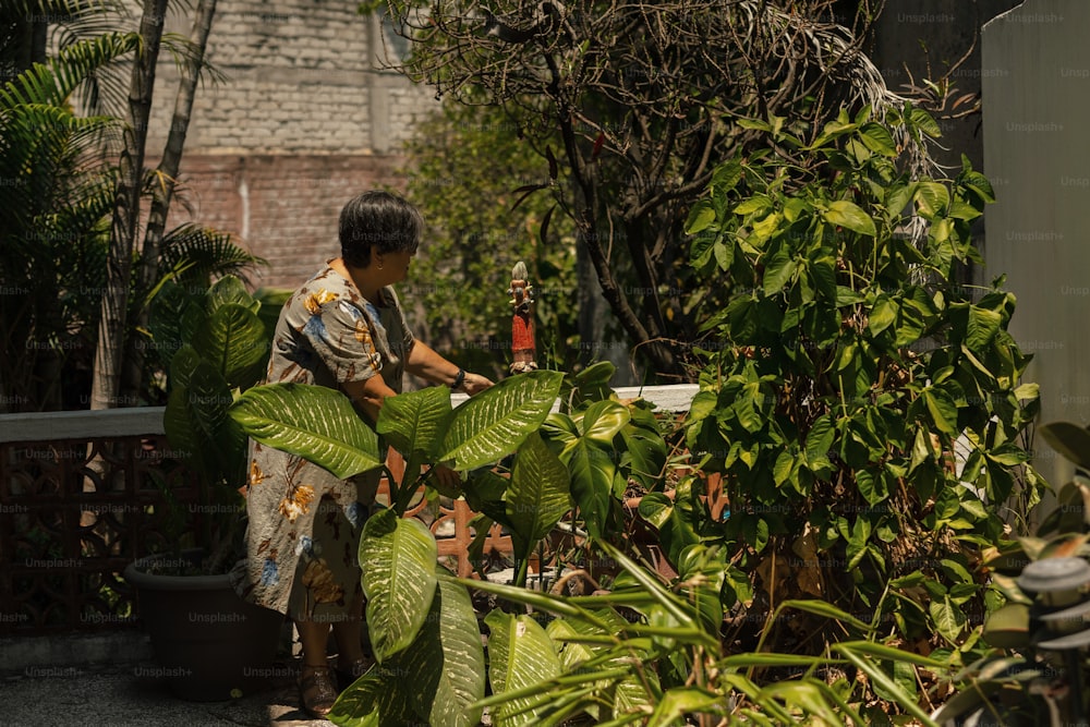 Une femme debout à côté d’une plante verte luxuriante