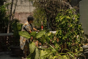 a woman standing next to a lush green plant