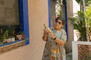 a woman standing outside of a building holding a cell phone