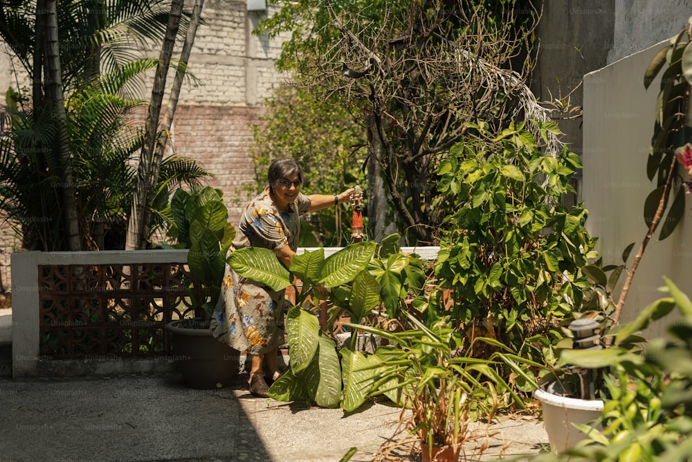 uma mulher de pé ao lado de uma planta verde exuberante