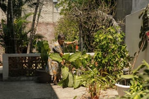 Una donna in piedi accanto a una pianta verde lussureggiante