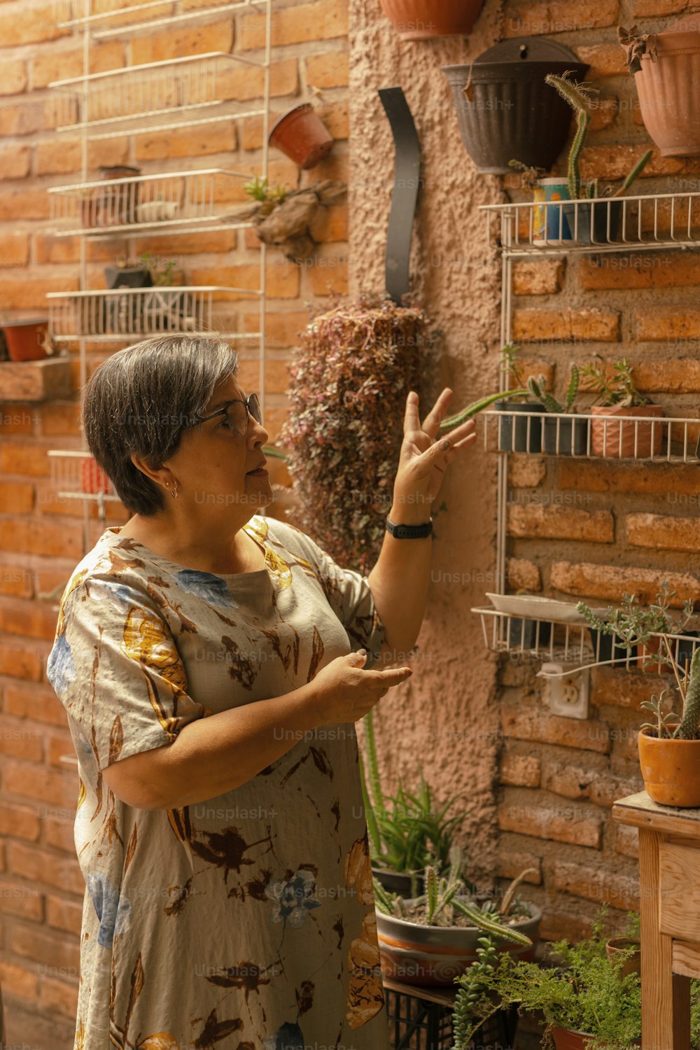 uma mulher em pé na frente de uma parede de tijolos