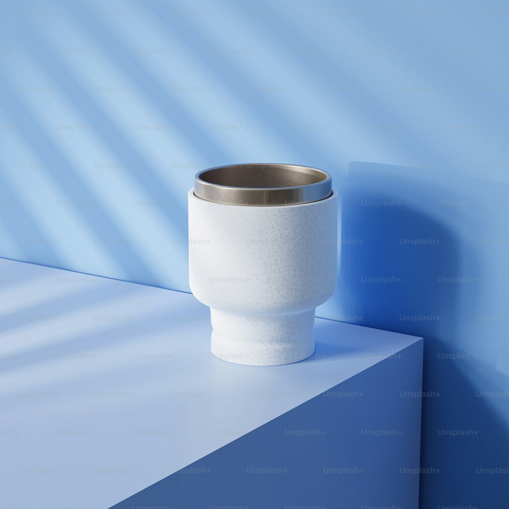 a white cup sitting on top of a blue shelf