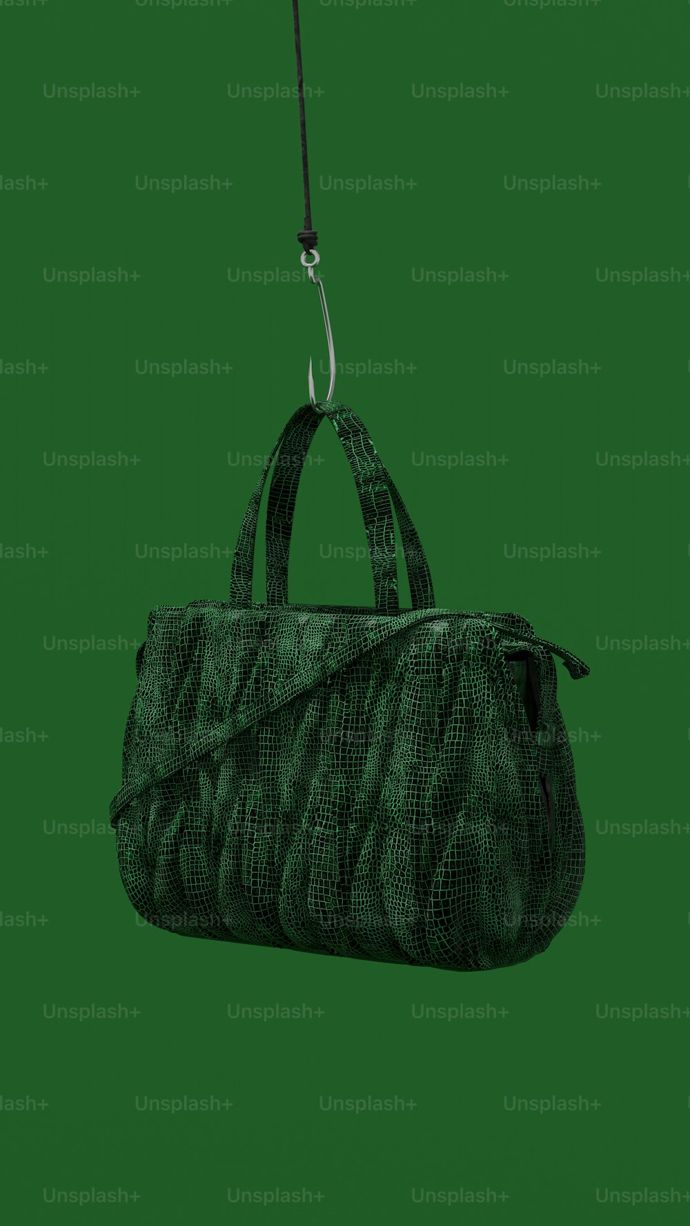 a handbag hanging from a string on a green background