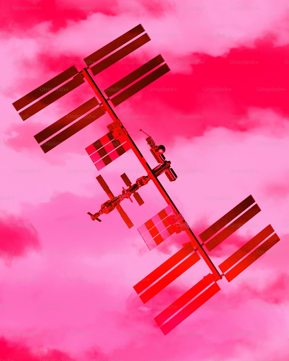 a plane flying in the sky with a pink background