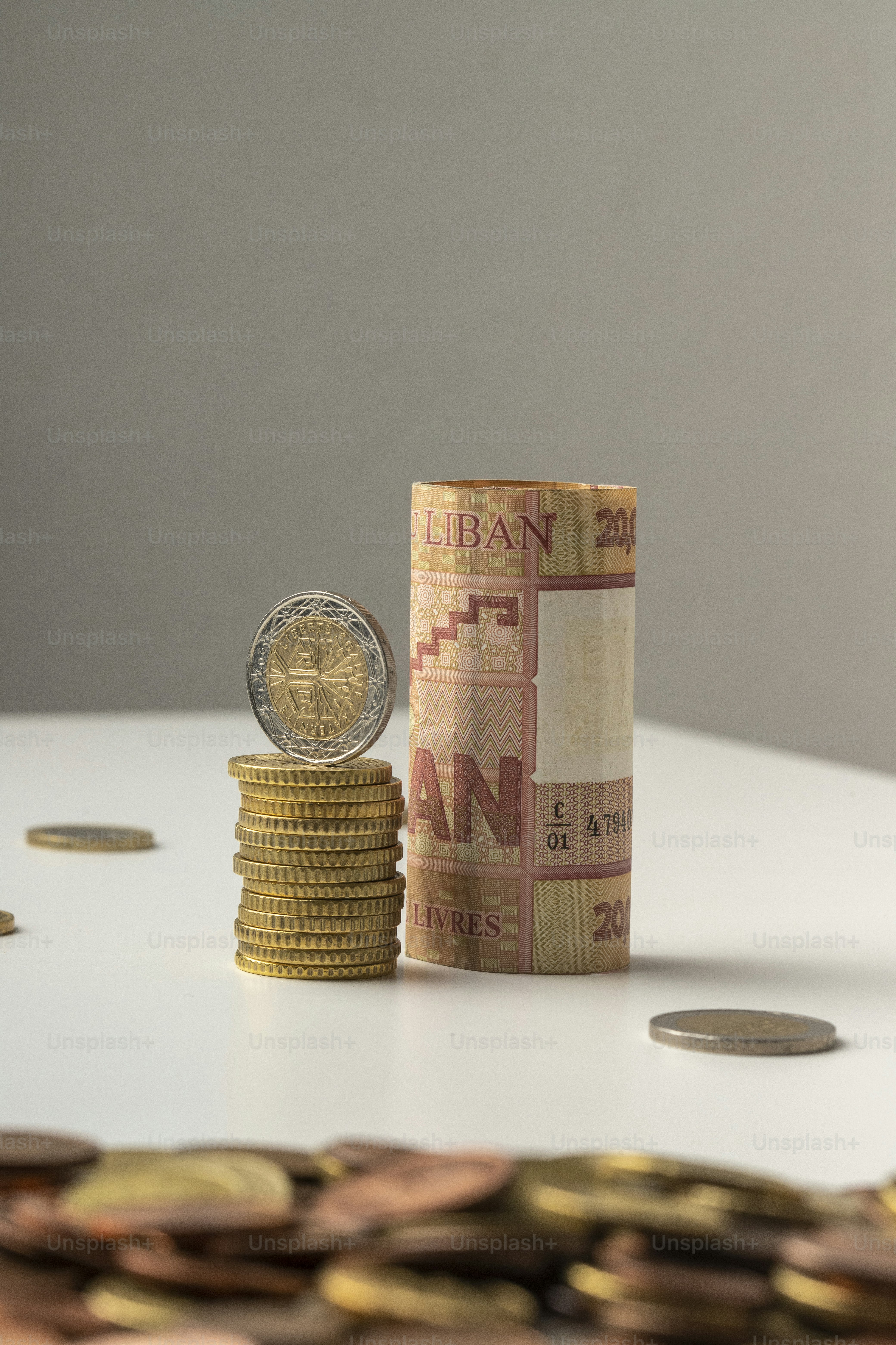 a stack of coins sitting next to a roll of money