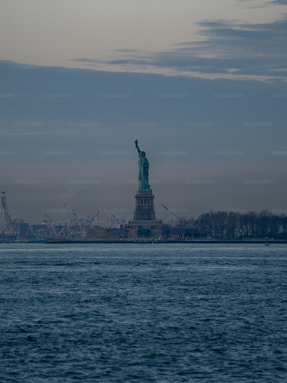 a large body of water with a statue of liberty in the background