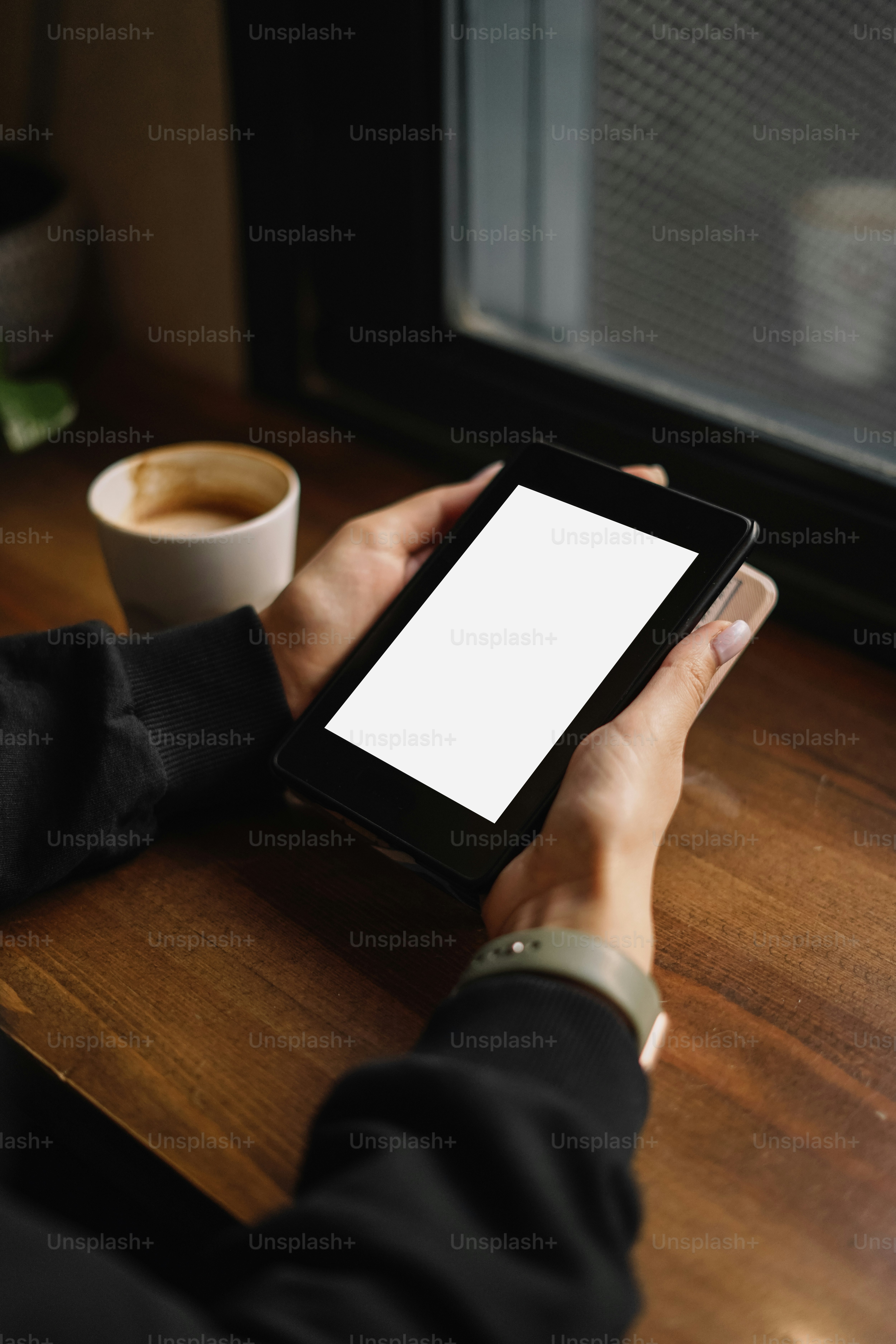 a person sitting at a table with a tablet
