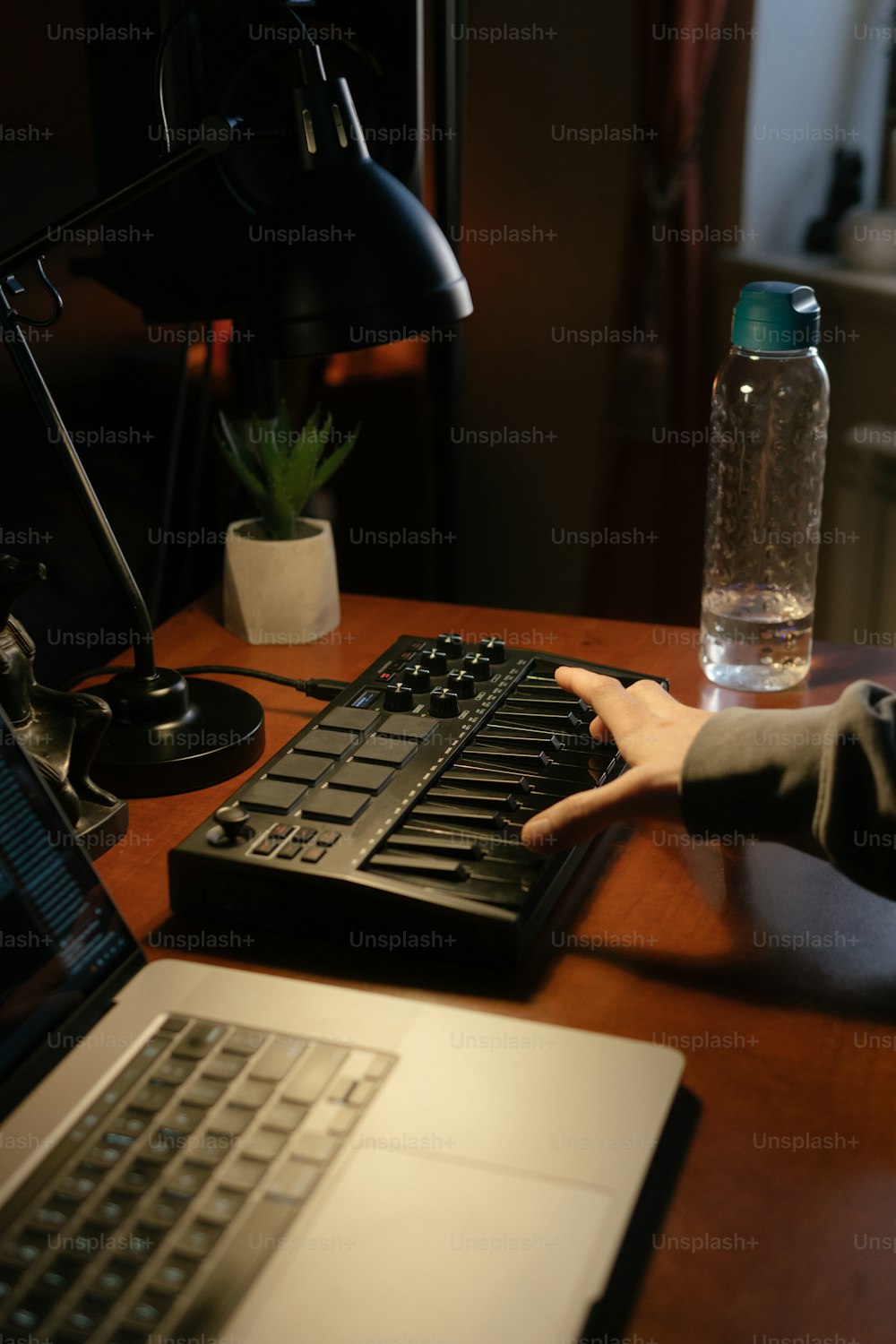 ラップトップの横にあるキーボードで入力している人