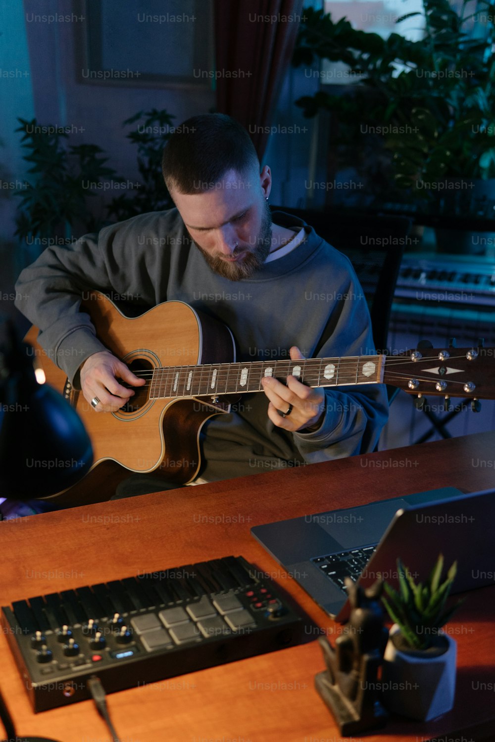 a man sitting at a desk playing a guitar