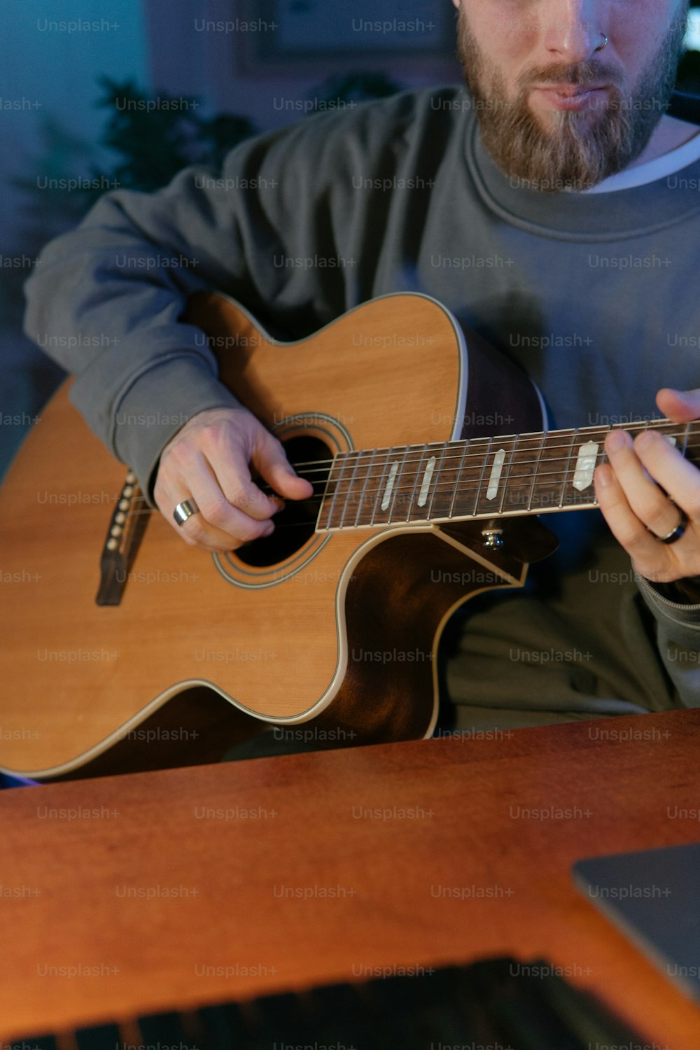 um homem sentado em uma mesa tocando uma guitarra
