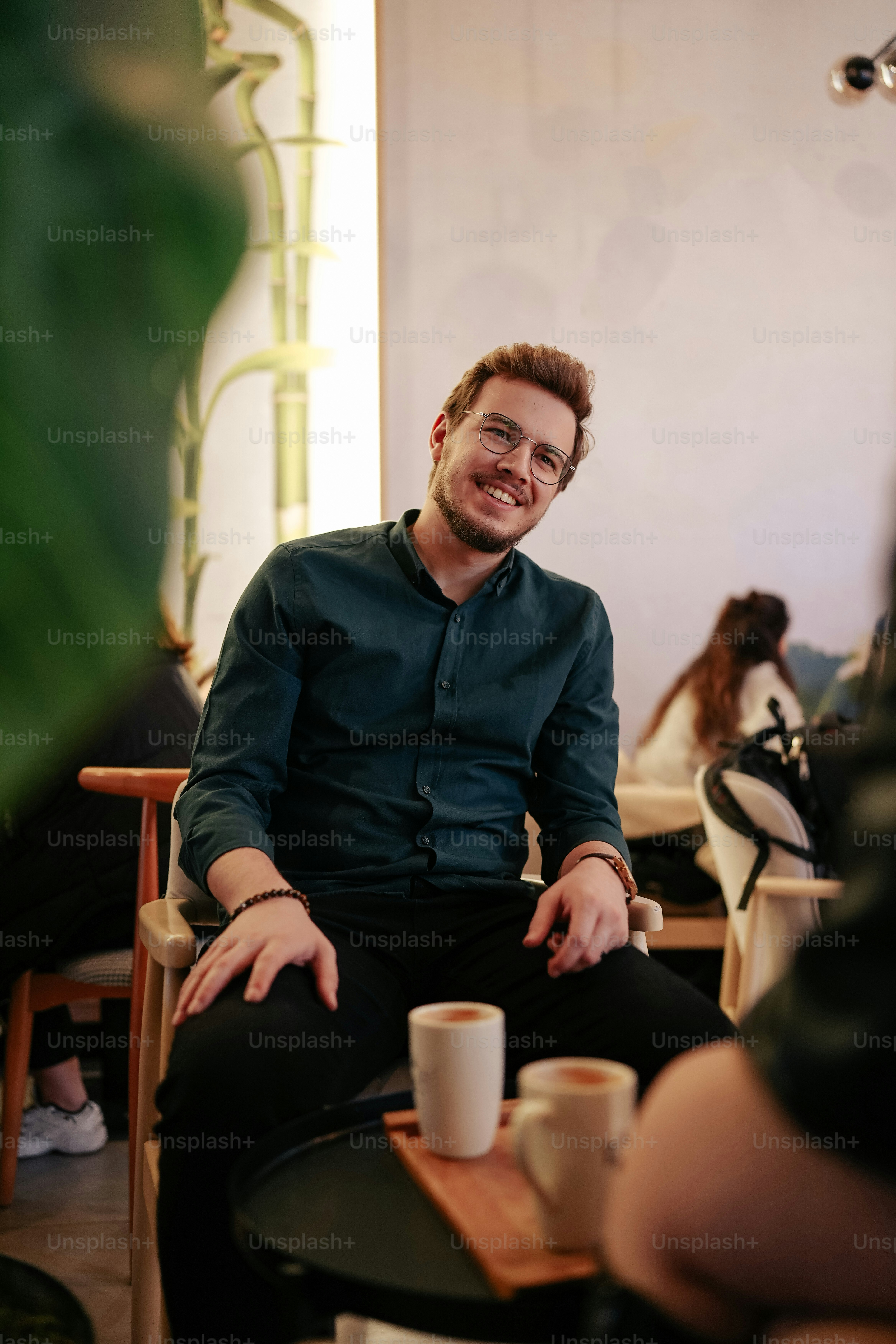 Un homme assis sur une chaise avec une tasse de café photo – Image de ...