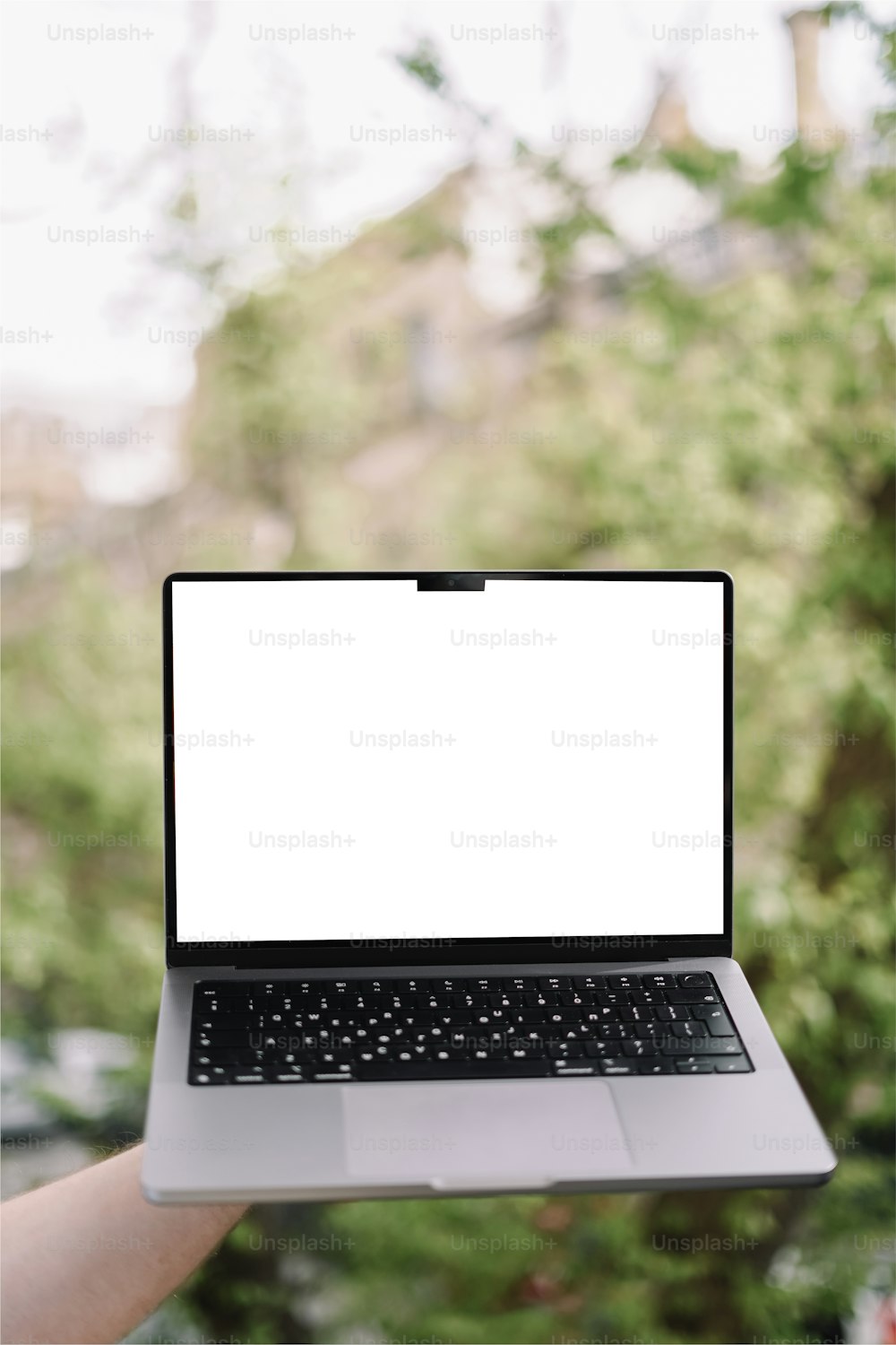 a person holding a laptop with a white screen