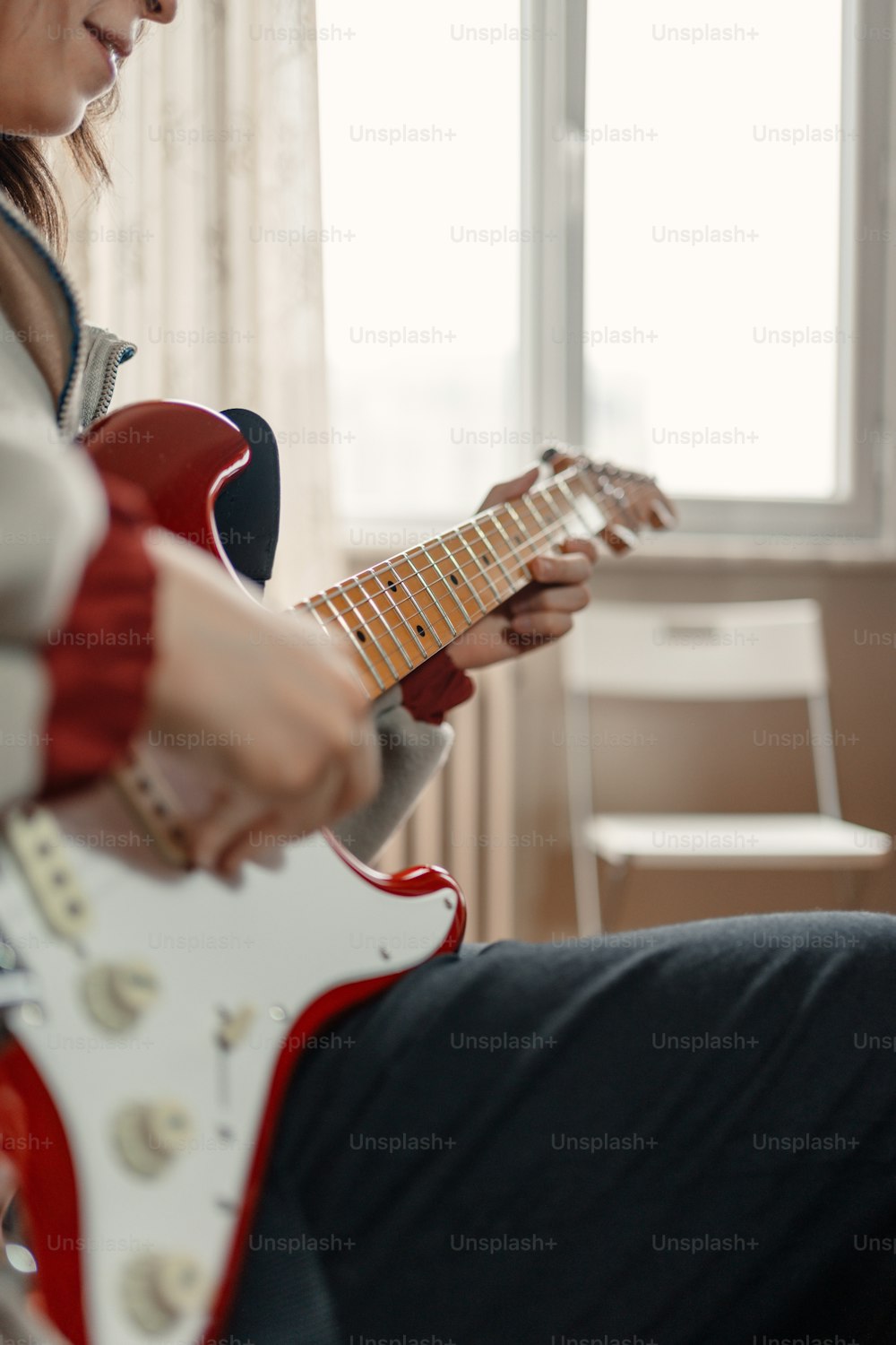 Eine Frau, die eine rot-weiße E-Gitarre spielt