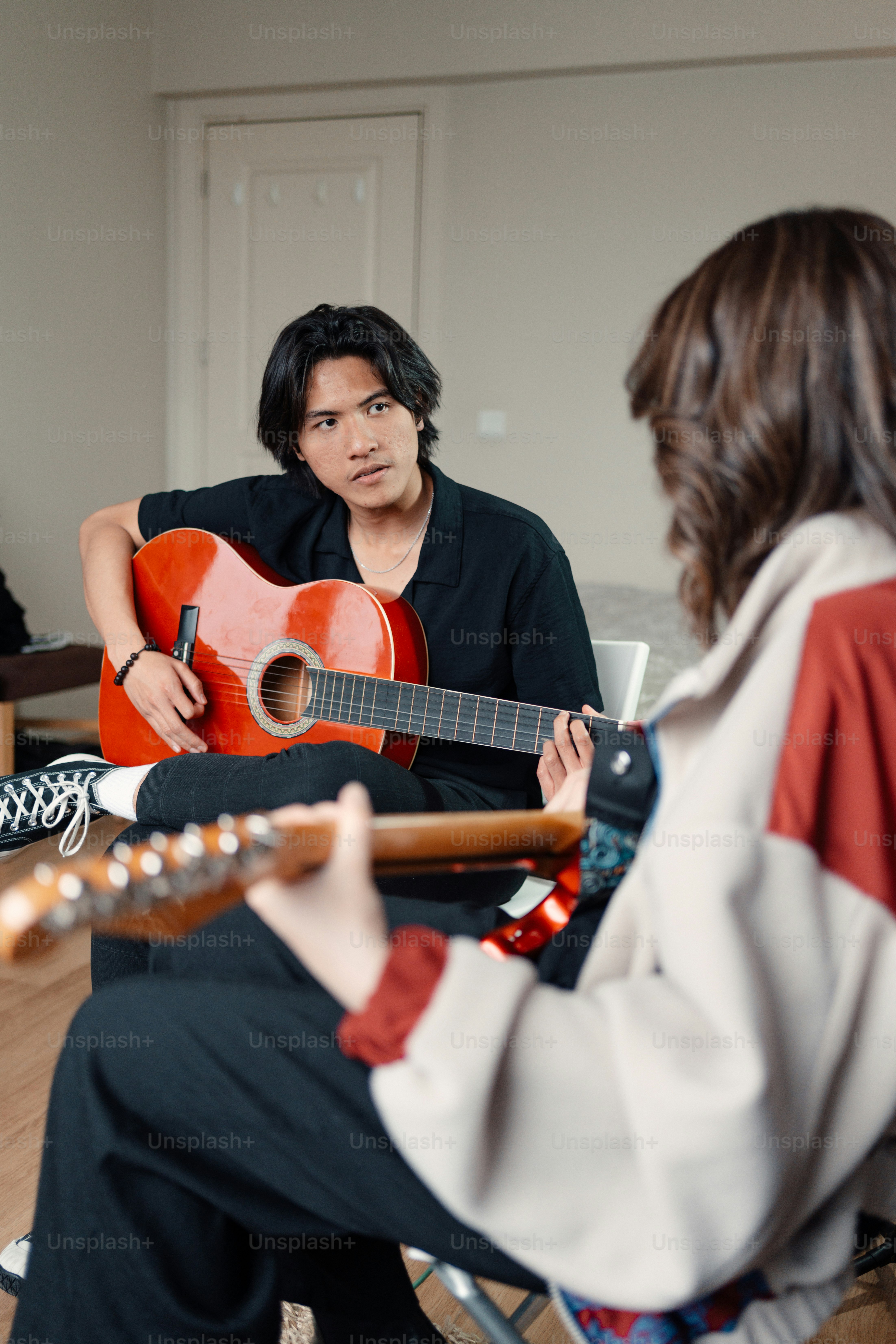 A man sitting in a chair playing a guitar photo – Playing guitar Image ...