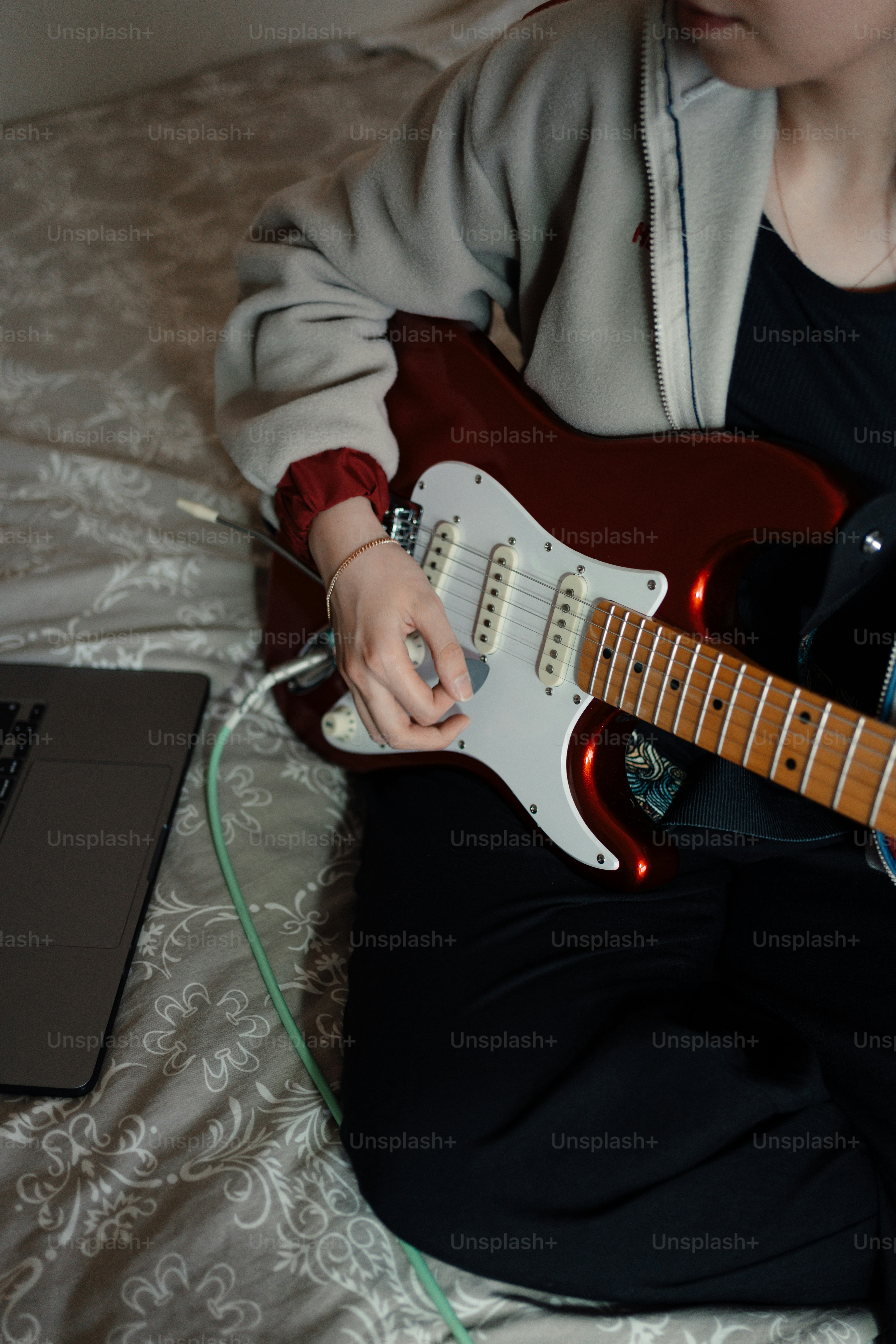 A person sitting on a bed playing a guitar photo – Music Image on Unsplash