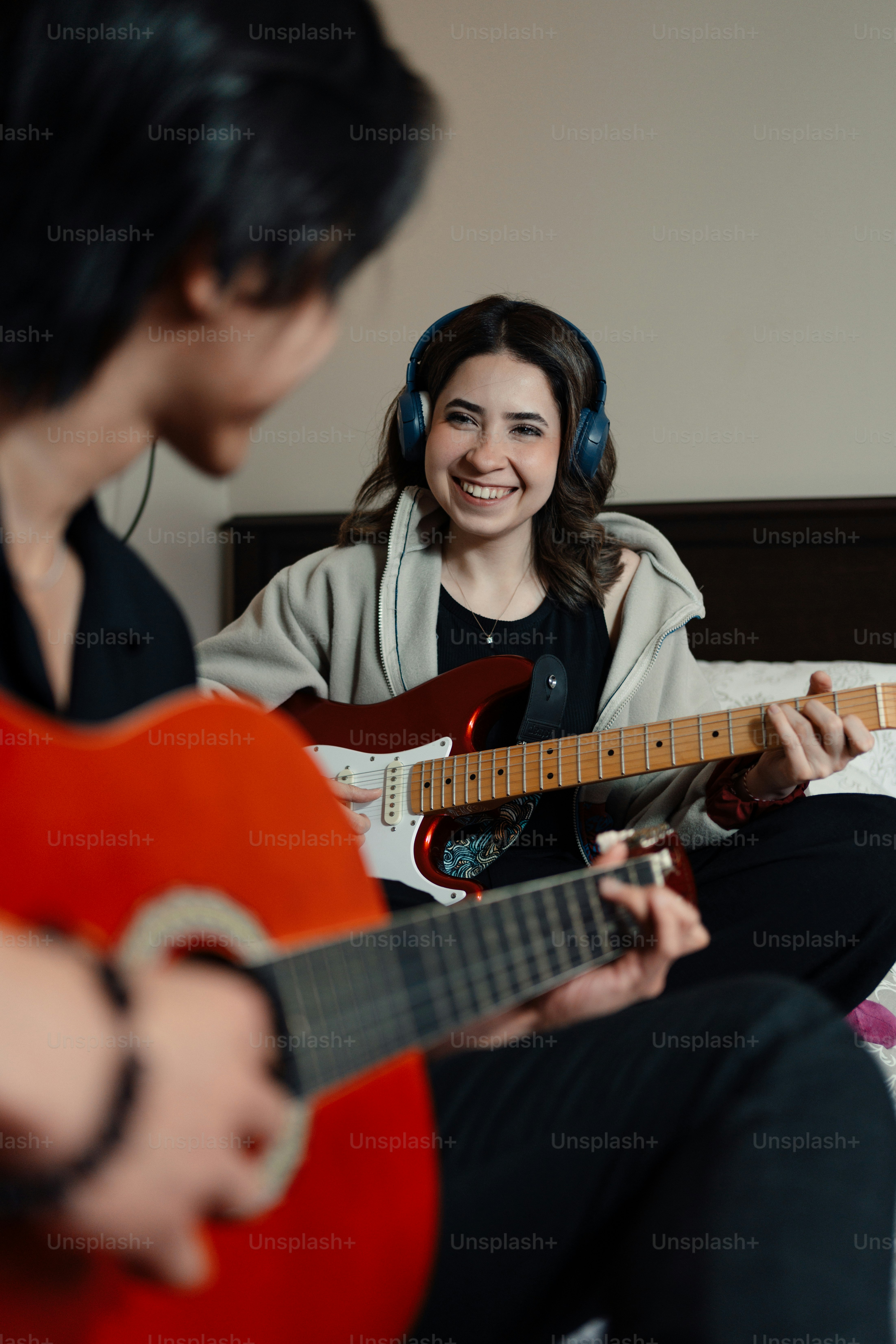 A person sitting on a bed playing a guitar photo – Music Image on Unsplash