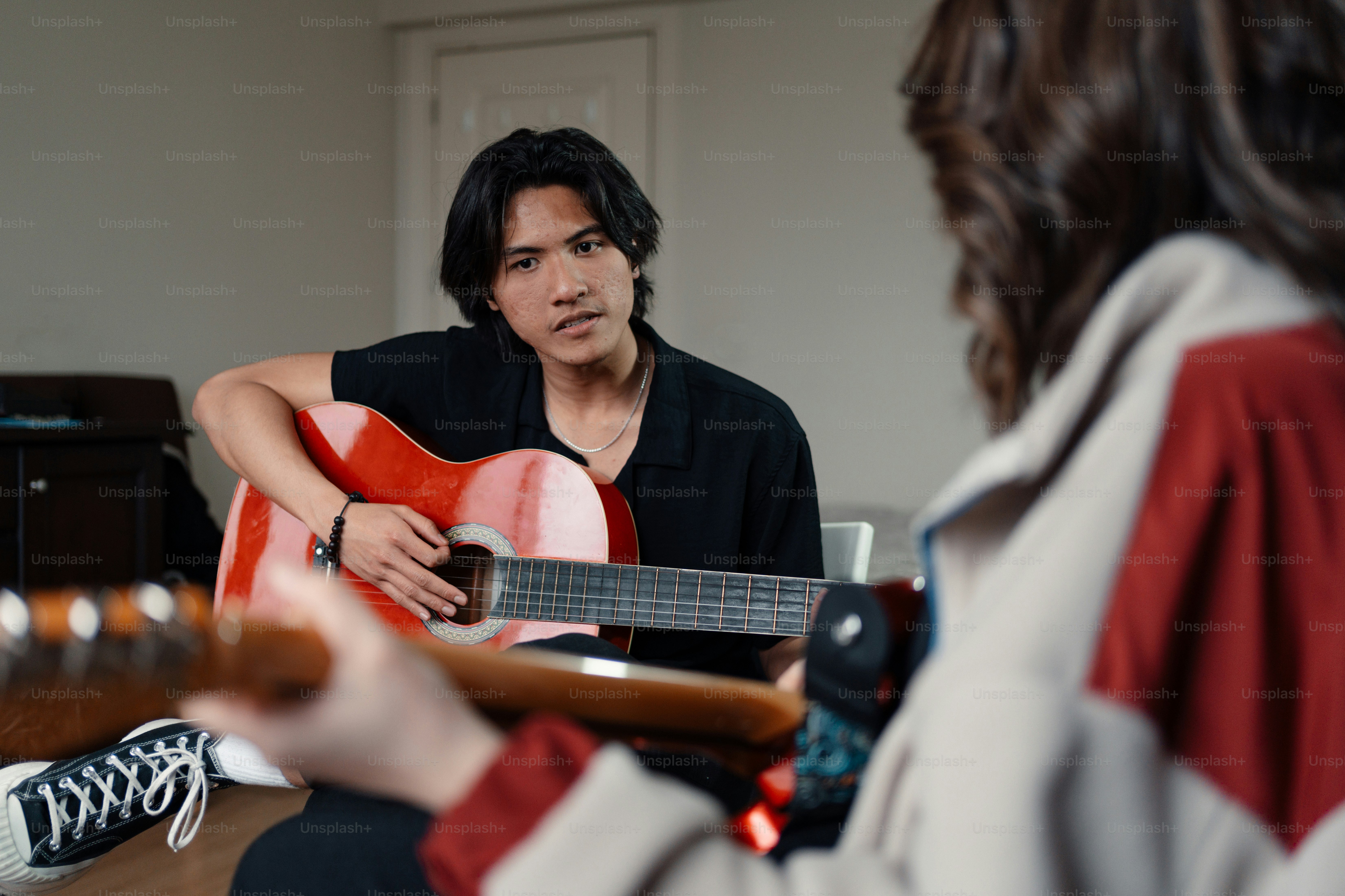 A person sitting on a bed playing a guitar photo – Music Image on Unsplash