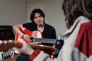 a man playing a guitar while a woman looks on