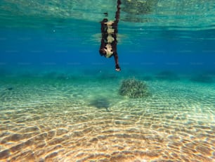 eine Person, die mit einem Surfbrett im Wasser taucht