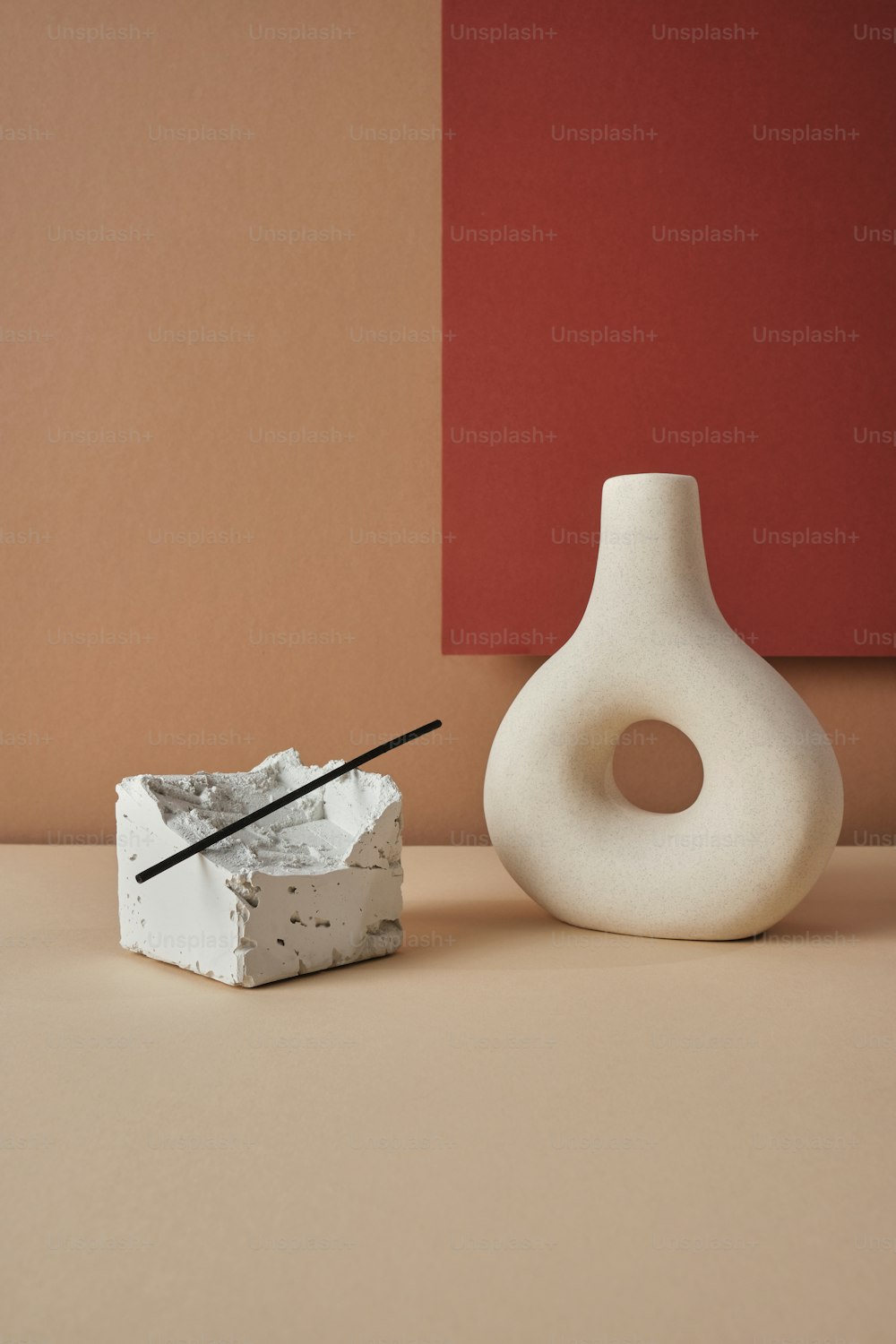 a white vase sitting next to a white object