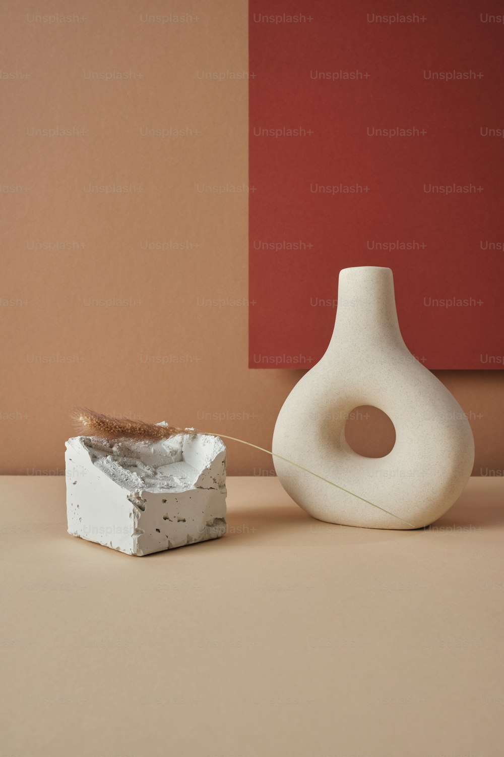 un vaso bianco seduto sopra un tavolo accanto a un oggetto bianco
