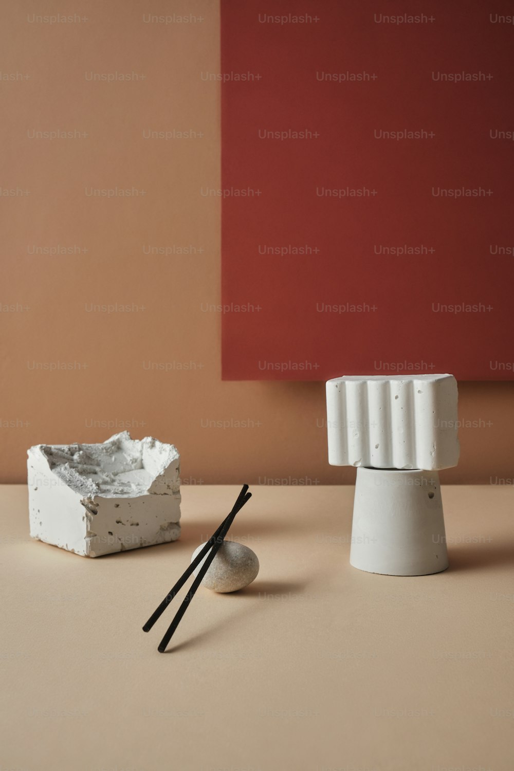 un objet blanc assis sur une table à côté de baguettes
