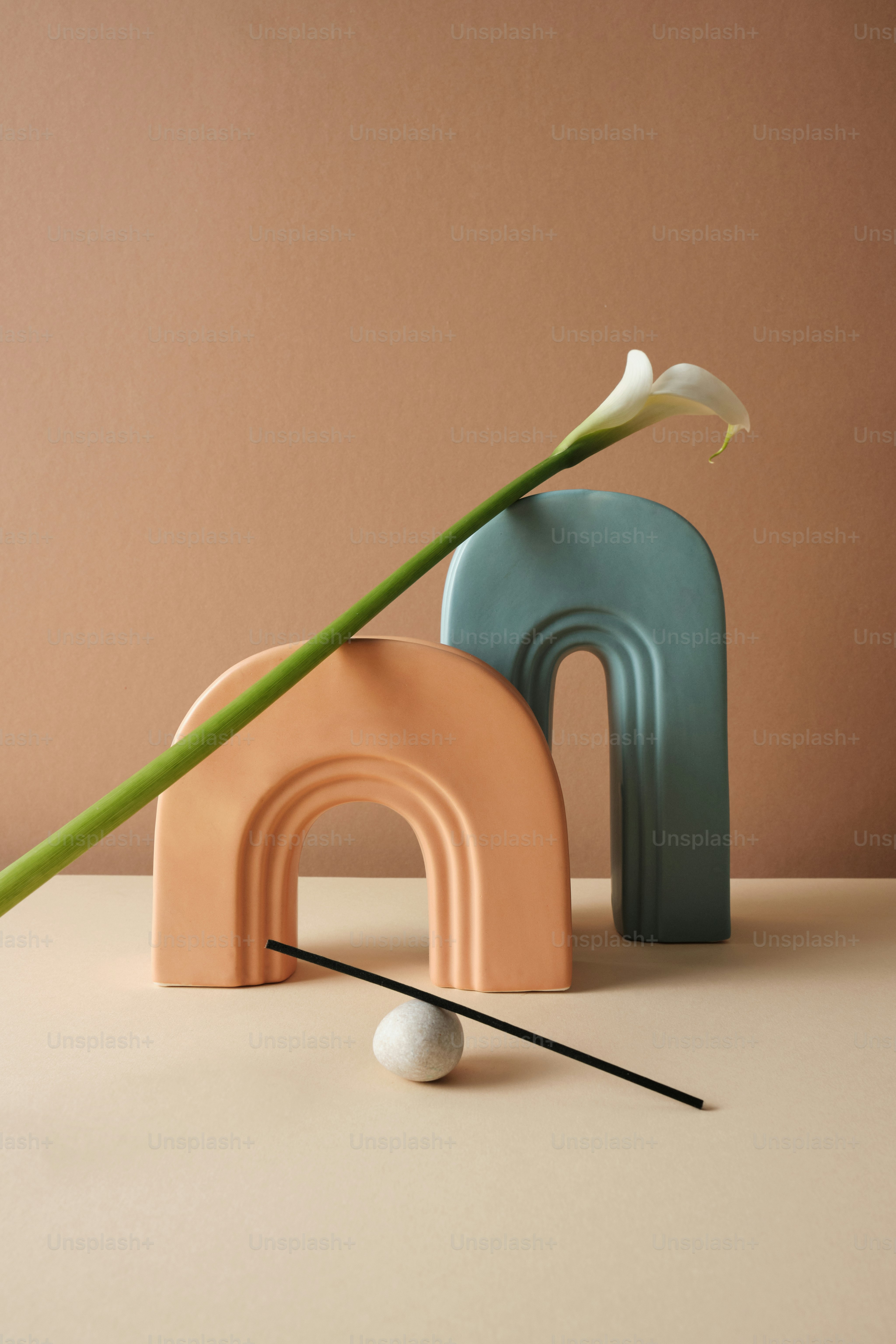 eine Vase mit einer Blume darin neben einer Skulptur