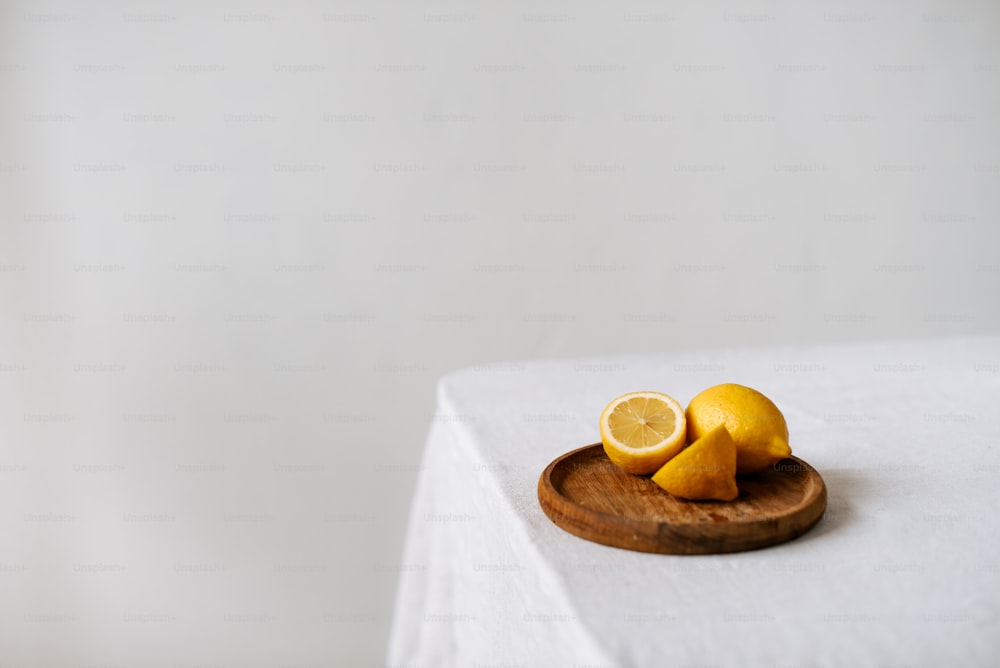 ein Holzteller mit Zitronenscheiben auf einem Tisch