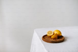 a wooden plate topped with sliced lemons on top of a table