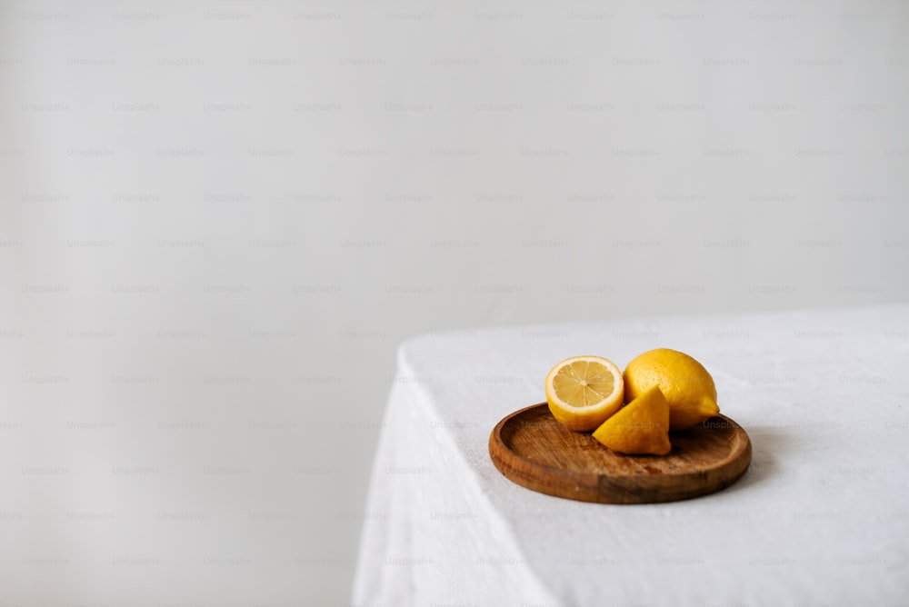 a wooden plate topped with sliced lemons on top of a table