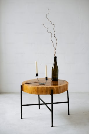 a table with two candles and a bottle on it