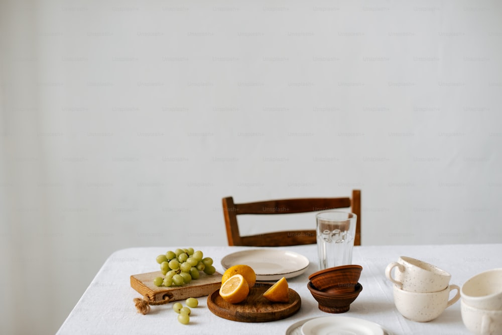 une table blanche surmontée d’assiettes et de bols remplis de fruits