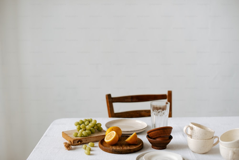 a white table topped with plates and bowls filled with fruit