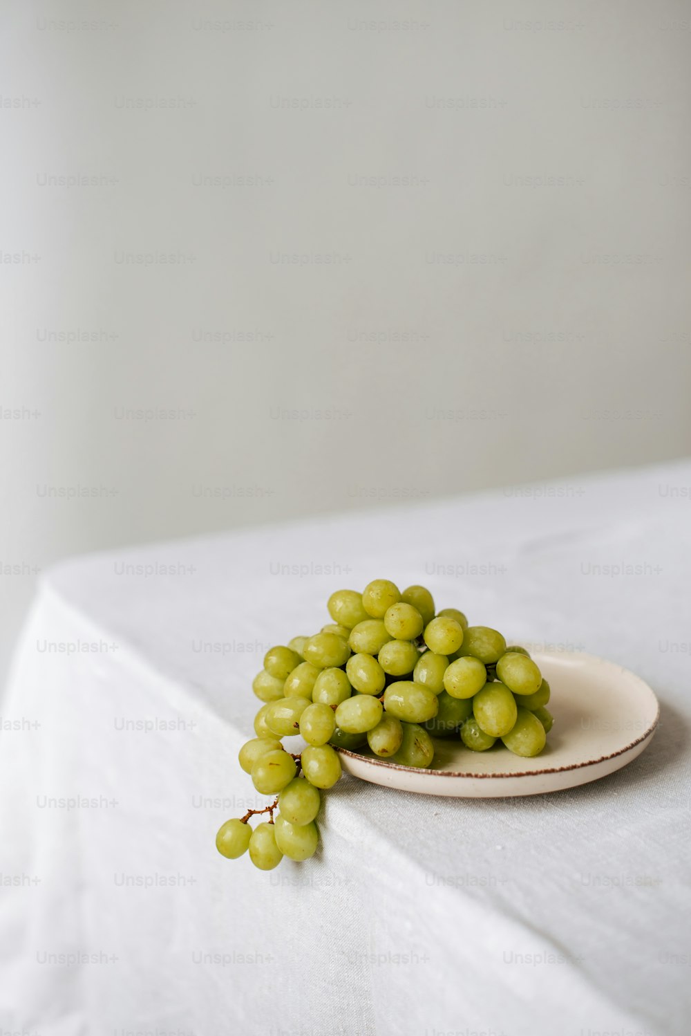 a plate of grapes sitting on a table