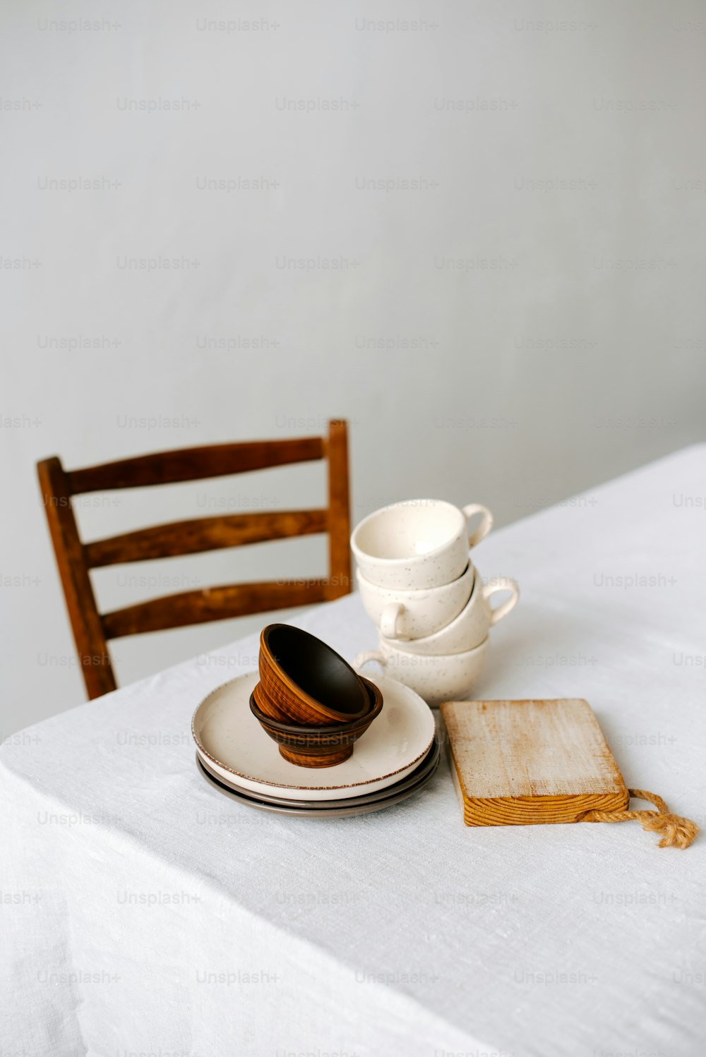 a table topped with plates and cups on top of a white table cloth