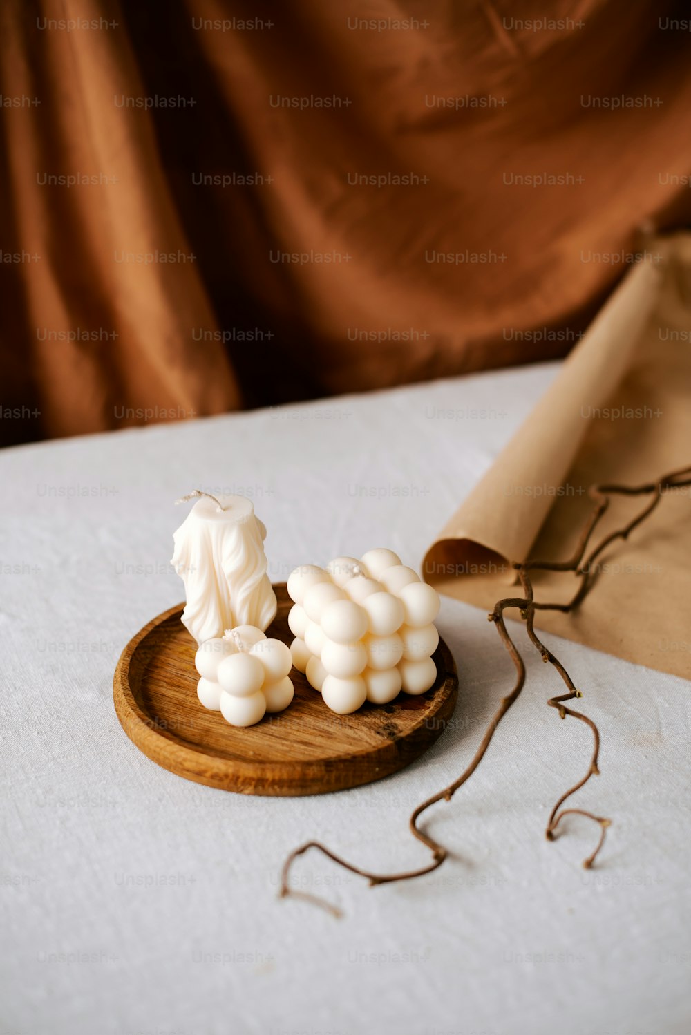 un piatto di legno sormontato da marshmallow sopra un tavolo