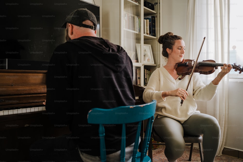 um homem e uma mulher que jogam violino em uma sala de estar
