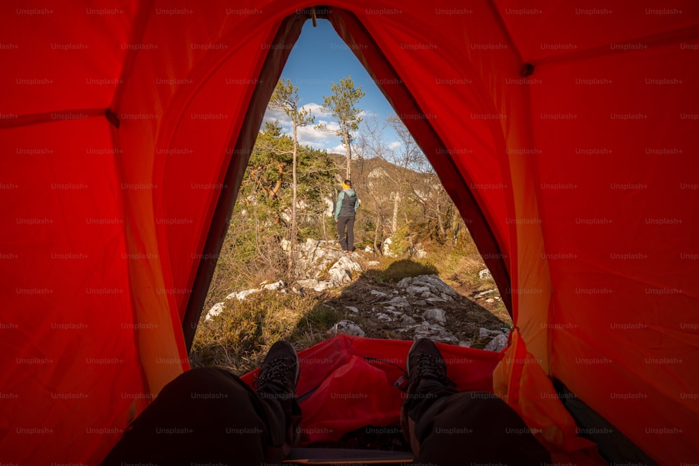 a man standing inside of a tent on top of a mountain