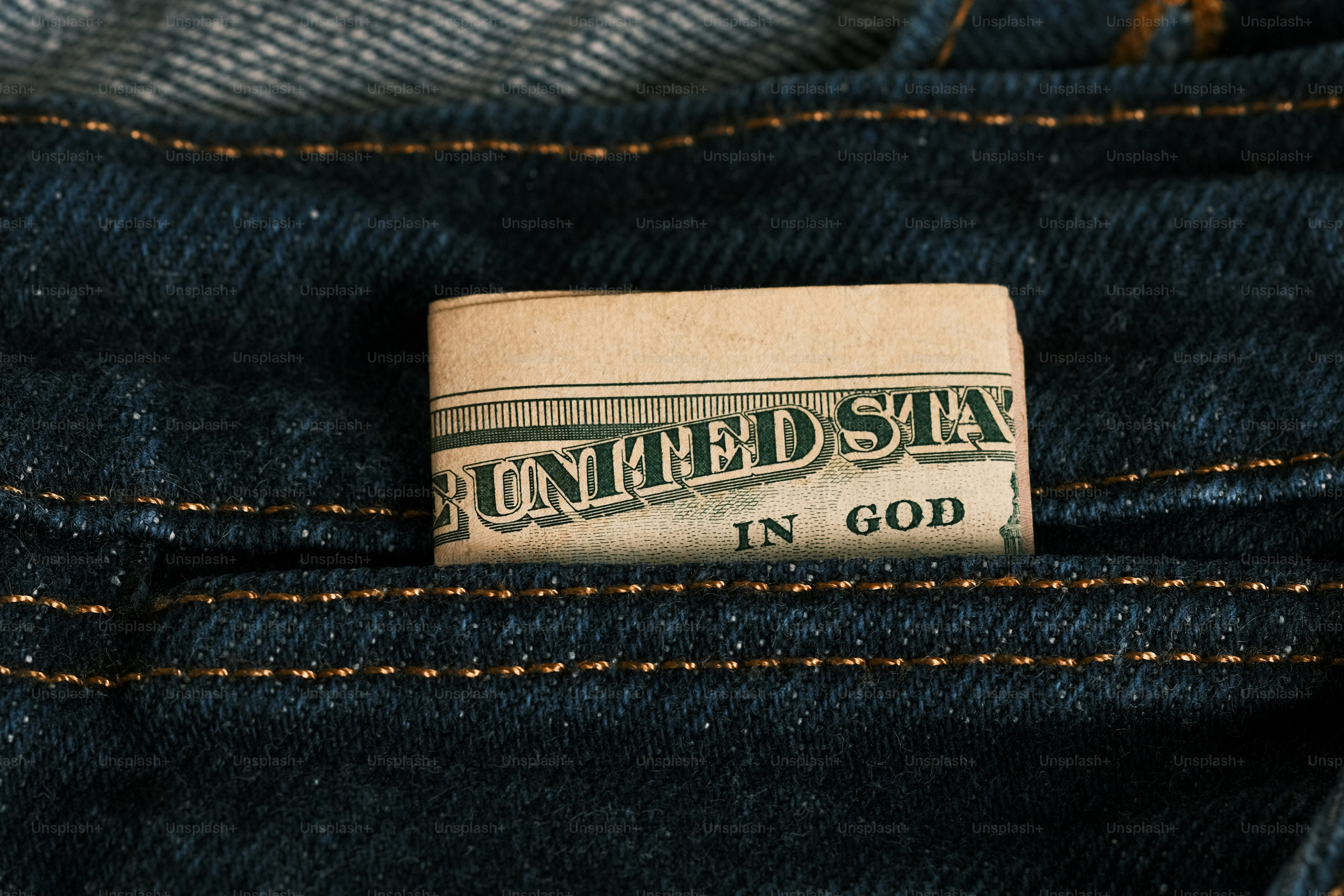 a one dollar bill sticking out of the back pocket of a pair of jeans