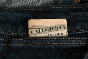 a one dollar bill sticking out of the back pocket of a pair of jeans