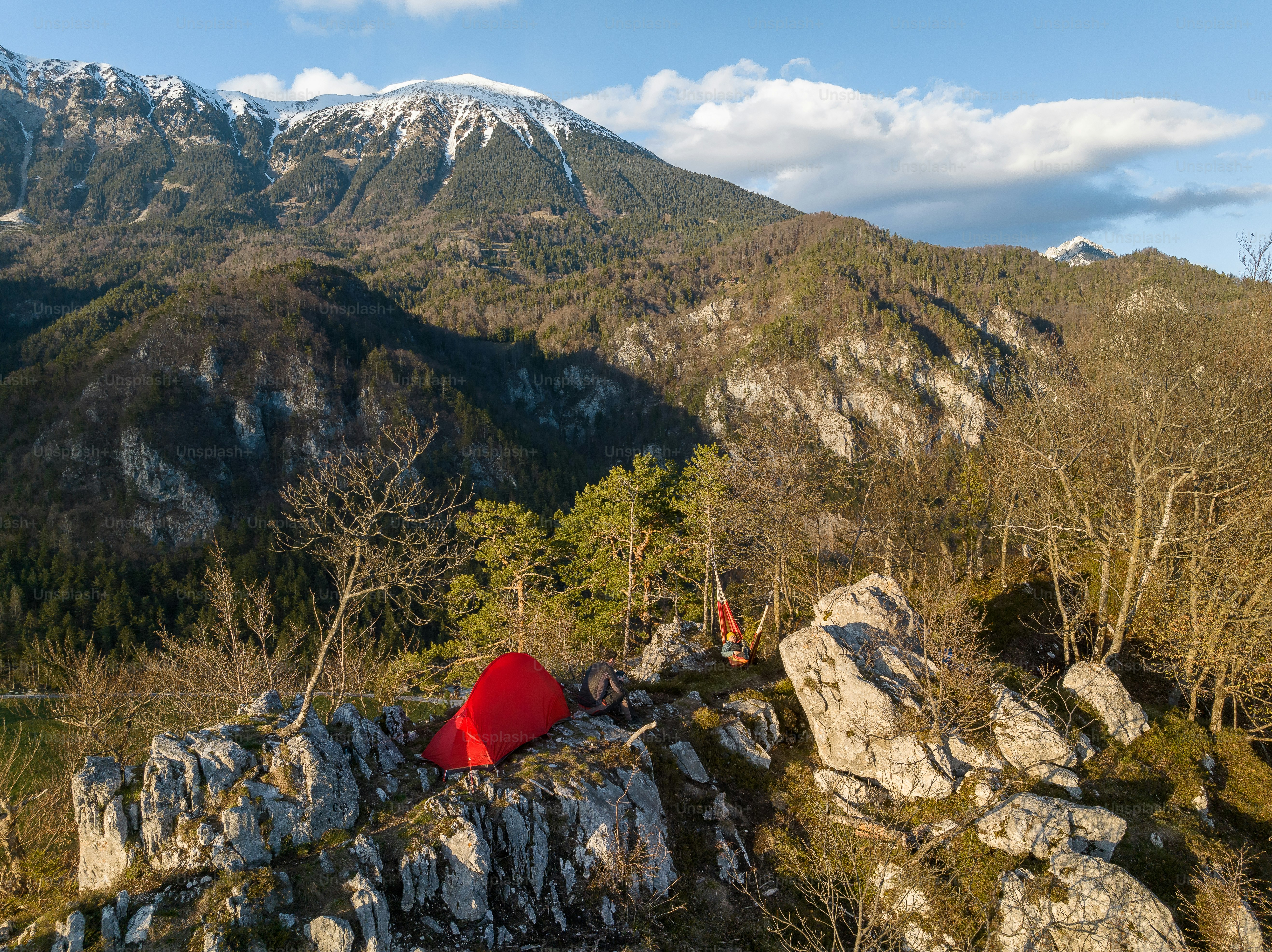 une tente rouge posée au sommet d’une colline rocheuse