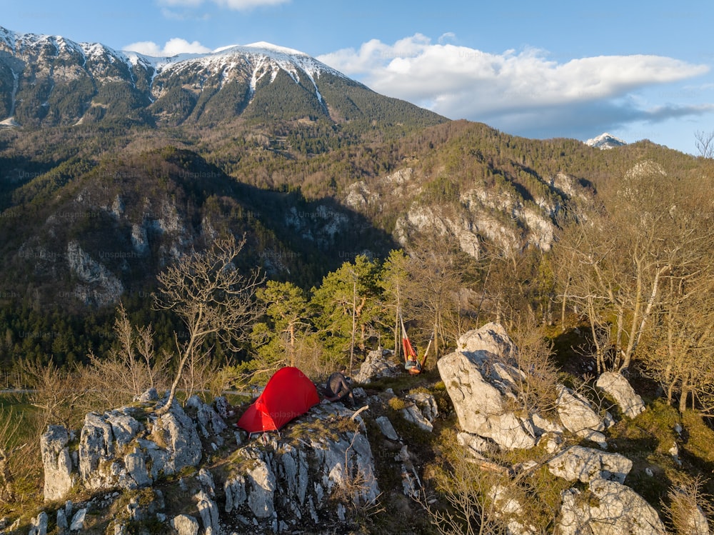 Una tenda rossa seduta sulla cima di una collina rocciosa