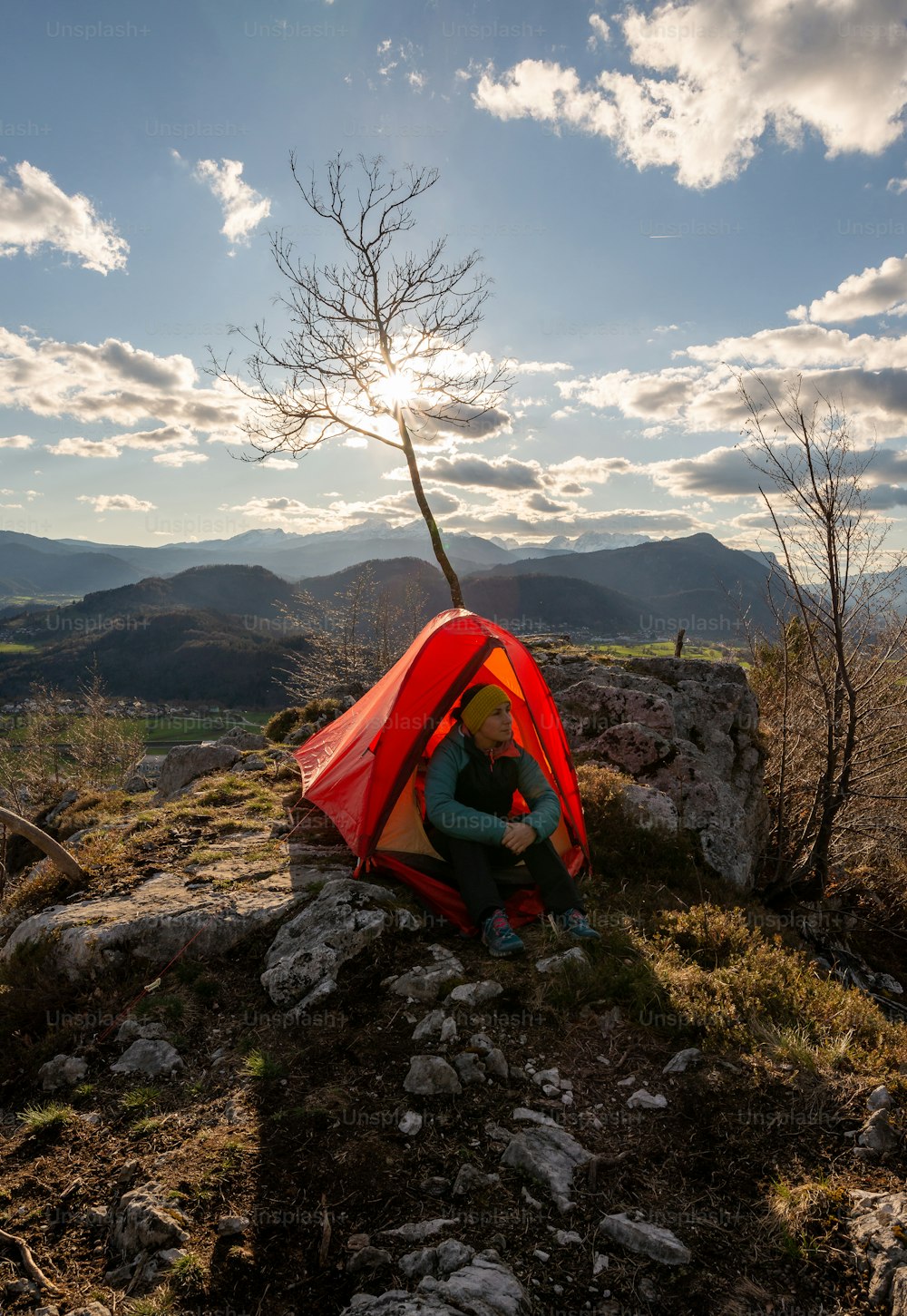 a person sitting in a tent on top of a mountain