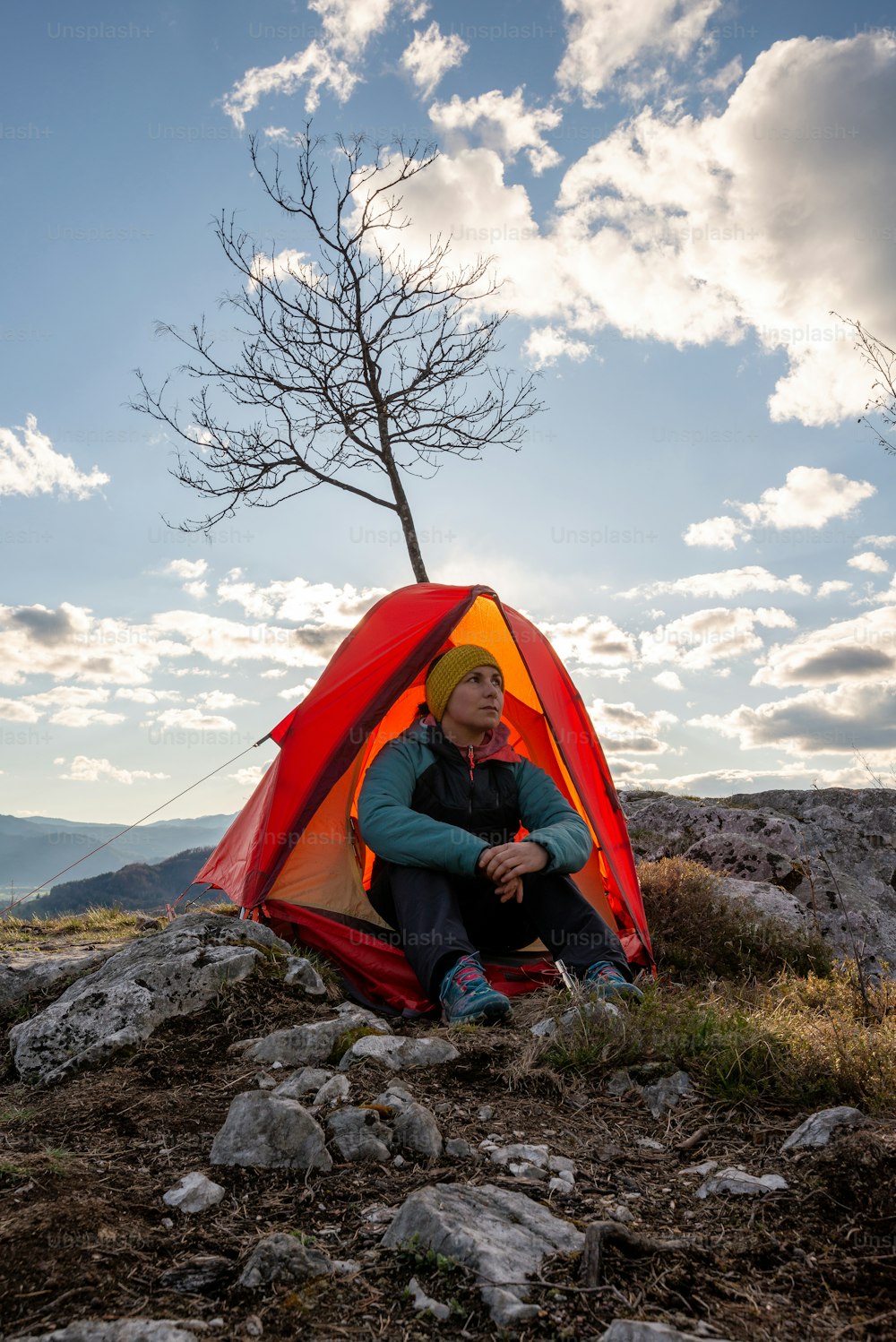 a man sitting in a tent on top of a mountain