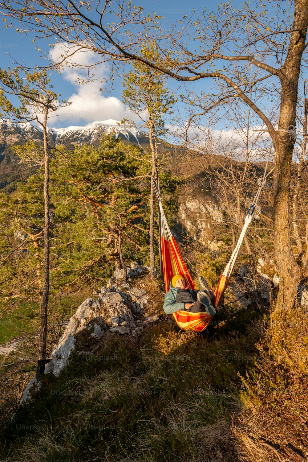 a man laying in a hammock in the woods